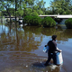 A man walks through a flooded street with his belongings in the Orlovista neighborhood following Hurricane Ian on October 1, 2022 in Orlando, Florida.